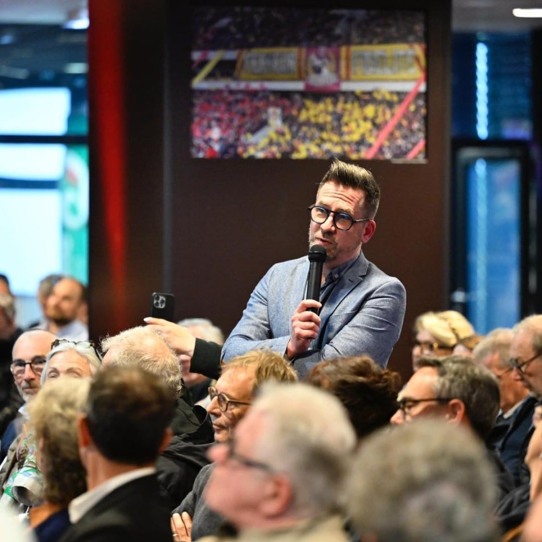 Jean-Christophe Camus, micro en main, au milieu des invités d'une soirée professionnelle