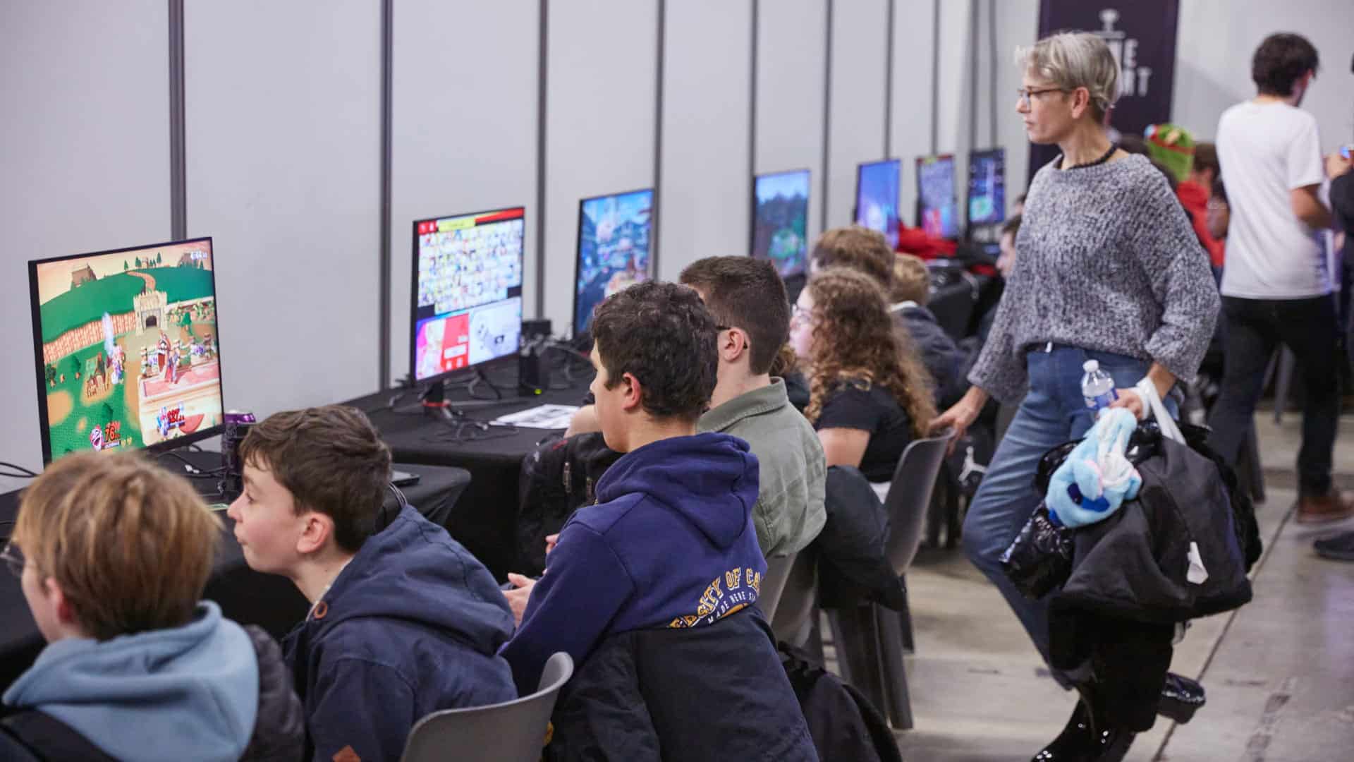 Visiteurs de tous âges aux postes de jeux vidéo en libre accès